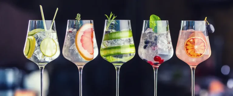 Fünf farbenfrohe, frisch gemixte Cocktails mit Eis, Früchten und Kräutern garniert, zubereitet vom mobilen Cocktailservice von Timo’s Kellnerservice.